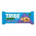 Bright blue packaging displays TRIBE x Wildfarmed branding above a close-up image of a golden oat flapjack studded with blueberries and almond pieces. Bold white type names the flavor, while small icons and nutrition text sit on a clean white background. An torn foil edge peeks out, casting a shadow.