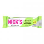 Image shows a N!Cks Protein Bar Hazelnut Chocolate in a glossy wrapper with a bold N!Cks logo. Brown and cream tones dominate; wrapper features a close-up of a chocolate-coated bar sprinkled with chopped hazelnuts, photographed against a plain white background.