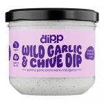 A photo shows six round tubs of Dipp Wild Garlic & Chive Dip with bright green labels featuring illustrations of wild garlic and chives. Clear lids reveal a pale green dip. Tubs sit neatly arranged on a plain white background with soft, even lighting. Soft shadows lie beneath each tub, adding depth.