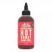 Six identical 260g glass bottles of Wilderbee Gochujang Hot Honey stand in a row on a white background. Each bottle reveals a glossy, deep reddish-honey sauce behind a clean white label with black and red lettering and metallic caps that catch soft studio light.