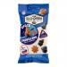 Bright blue and black pouch shows retro astronauts and rockets orbiting a silver moon-shaped pile of black licorice pieces. Bold Van Slooten logo and 'Space Travellers' lettering appear in white and red. Star speckles and gleaming highlights create a playful cosmic snack motif. Shiny foil accents. On pouch.