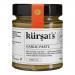 Photo shows twelve 180 g tubs of Kursat's Garlic Paste arranged in a neat grid. Each tub displays a clear label with the brand name and weight, white lids and uniform packaging form a repeating pattern. The paste looks smooth and pale, with slight texture visible on the surface. Shadows fall softly.