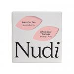 A rectangular cardboard box in warm cream tones sits centered, showing 'Nuditea Breakfast Tea' branding in bold brown type. Eco icons and 'plastic free' wording appear; simple tea-leaf illustrations decorate the front. Weight and quantity labels are printed in small clear text. A soft shadow drifts.