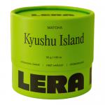 Six small matte-green tins labeled 'Lera Matcha' and 'Kyushu Island' sit in neat rows on a pale surface. One tin is open, revealing vibrant emerald-green powder; a wooden scoop rests beside it. A minimal, clean background emphasizes the bright green matcha. Soft light casts gentle shadows and depth.