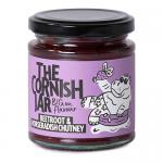 Six glass jars are arranged in neat rows, each filled with deep ruby beetroot chutney and sealed with silver lids. Clean white labels carry black lettering and a simple logo. Light highlights the glossy surface and chunky texture of the preserves.