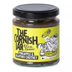 Six clear glass jars of Pineapple & Jalapeno chutney sit in a neat pack, each showing golden-yellow preserve studded with red and green pepper flecks. White labels with The Cornish Jar branding wrap the jars; metal lids reflect light and clear shrink-wrap holds the set together arranged in two rows