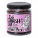 Six glass jars sit in a neat row, each filled with jewel-toned spreads: deep blackberry purple, soft apple gold, and creamy vanilla amber. Labels display The Cornish Jar logo and flavor names, while metal lids catch light, and textured fruit imagery decorates each label. on a pale wooden surface lit