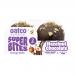 A glossy snack pack sits front and center, featuring the Oatco logo in bold warm brown letters. The wrapper shows hazelnut and chocolate imagery, toasted oat graphics, and a partially unwrapped bar revealing a nut-speckled, chocolate-coated bite. Bright accents and clean layout. Subtle matte finish..