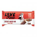 A slender rectangular bar sits inside a glossy wrapper in pale cream and soft pink tones, featuring the LoveRaw logo and stylized wafer imagery. The wrapper shows a cross-section of layered wafers and milk chocolate, with crumbs and chocolate drizzle accenting the design. Rear panel lists info text.