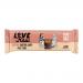 Photo shows twelve LoveRaw Almond Butter Cups in bright individual wrappers, arranged in a neat grid with one unwrapped cup revealing a creamy almond filling and glossy chocolate coating. Packaging uses earthy browns and soft pastel accents with clear logo and product name. On pale neutral backdrops.