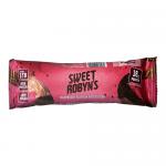 A glossy rectangular wrapper features a chocolate bar image beside vivid raspberries and red syrup splashes. The Sweet Robyn’s Confectionery logo appears in playful script across the center. Background mixes deep brown and raspberry pink with small nutrition panels at the edges. foil seal along edge.