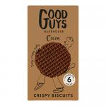 A clean photo shows a Good Guys Bakehouse Biscuit Melts cocoa pack and its contents. Shiny, round cocoa biscuits with slightly cracked tops and fine cocoa dusting sit stacked beside an open box displaying warm brown packaging and clear brand labeling, on a light tabletop. Soft shadows deepen details.