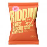 Image shows a compact display of thirty bright snack pouches, each labeled Riddim Snacks Sweet Biscuit Popcorn. Glossy yellow-and-orange bags sit in a neat grid, with overflowing popcorn kernels and biscuit pieces visible through a small transparent window on each pack. A bold logo crowns the top.!!