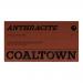 Image shows a compact grocery pouch in matte black and charcoal gray, featuring a bold white 'Coaltown' logo and a stylized coal graphic. A small clear window reveals glossy dark pieces; minimal sans-serif text appears along the edges.