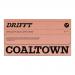 An upright matte coffee pouch displays the Coaltown Drifft logo and 'Half Decaf' label in bold. Warm brown and deep charcoal tones frame a simple typeface and a small illustrative coal-mine motif. Crisp edges, a resealable top and subtle texture convey tactile detail. silver trim catches soft light.