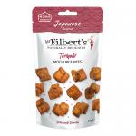 A colorful pouch shows the Mr Filberts logo with Japanese-inspired red and white graphics. Close-up reveals glossy bite-sized mochi rice pieces, golden-brown and lacquered with teriyaki glaze, sprinkled with sesame seeds, spilling beside the open packet on a neutral surface.
