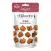 A colorful pouch shows the Mr Filberts logo with Japanese-inspired red and white graphics. Close-up reveals glossy bite-sized mochi rice pieces, golden-brown and lacquered with teriyaki glaze, sprinkled with sesame seeds, spilling beside the open packet on a neutral surface.