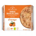A photo shows flat, golden-brown round tortas arranged beside a cream-and-orange packet labeled Ines Rosales, featuring an orange illustration and olive motifs. The biscuits display a glossy, slightly cracked surface and crisp, flaky edges.