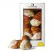 The photo shows four 200g Di Santo Amalfi Coast Aragsotina packs arranged on a sunlit surface. Each Mediterranean-themed package features coastal illustrations and a clear window revealing golden-brown, slightly irregular biscuits with a crumbly texture. Bright lemon and sea hues frame the scene now.