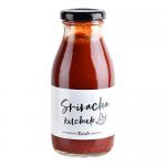 A photo shows six identical Hawkshead Relish Sriracha Ketchup bottles standing in two rows. Clear bottles reveal bright red sauce; white labels feature the Hawkshead logo and bold red lettering. Red caps top each bottle against a plain white background.