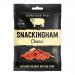 A photo shows twelve 35g packets of Serious Pig Snackingham Classic charcuterie arranged in a neat grid. Each slim packet displays a matte earth-toned wrapper, a bold pig logo, clear product name text, and a close-up image of thinly sliced cured pork.