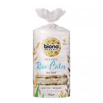 A bright cardboard box sits against a plain background, showing a clear image of stacked round wholegrain rice cakes. The packaging displays the brand name in bold, organic logo, salt description and nutritional callouts, with natural beige and green color accents. Subtle kraft texture frames label.