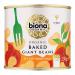 A green-and-white tin shows the Biona logo and a photo of large pale beans in vivid red tomato sauce. Organic certification marks, ingredient text and the 230g weight sit on the label; six cans are pictured together.