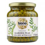 A bright, green Biona Organic Garden Peas package sits front and center, the Biona logo prominent at the top. A cluster of glossy peas spills from a wooden scoop across the foreground. The label shows organic badges, the product name and weight against a clean white background. with soft highlights .
