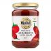 Photo shows a clear glass jar of Biona Organic Arrabbiata Hot & Spicy pasta sauce. Deep red, slightly textured sauce fills the jar. The white label bears green and red branding, product name and ingredient text. A metal lid seals the top. It sits on a neutral surface, softly lit, with chilli flecks.