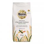 A clear-front bag shows tightly coiled tri-colour fusilli—deep green, pale beige and rich red spirals—textured from bronze extrusion. A kraft-style label displays the Biona Organic logo, product name and weight, with a plain white backdrop and minimal shadowing. Light reflects off the glossy film. .