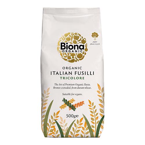 A clear-front bag shows tightly coiled tri-colour fusilli—deep green, pale beige and rich red spirals—textured from bronze extrusion. A kraft-style label displays the Biona Organic logo, product name and weight, with a plain white backdrop and minimal shadowing. Light reflects off the glossy film. .