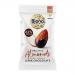 An open pouch and several small packets of Biona Organic Dark Chocolate Roasted Almonds sit on a pale wooden surface. Glossy, dark chocolate-coated almonds spill out beside scattered whole nuts. Packaging features the Biona logo, organic wording and earthy green and cream tones. Soft natural glow!!!
