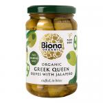 A clear glass jar holds glossy green Greek Queen olives, each pitted and stuffed with bright jalapeño slices, submerged in pale brine. A natural-toned label displays organic branding and product name; light reflections and droplets accentuate the texture and sheen.