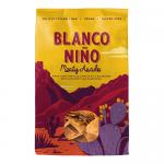Bright red and yellow bag of Blanco Niño Meaty Asado tortilla chips sits upright, showing a bold logo and sizzling grilled meat imagery. Crisp triangular chips peek from a transparent window, while seasoning flecks and texture detail highlight crunchy, savory surfaces. Glossy finish subtly reflects.