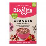 A tall matte box with vivid berry illustrations and a clear window reveals clusters of granola studded with dried berries and seeds. The bold logo sits above nutritional text and pastel accents; a torn-open corner shows crunchy oat clusters spilling onto a white surface. Soft shadows fall across it.