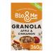 A resealable pouch of Bio&Me Apple + Cinnamon Gut-Loving Granola sits beside a bowl of golden clusters, scattered oats and dried apple pieces. Cinnamon sticks and fresh apple slices frame the scene on a wooden surface, with soft natural light highlighting crunchy textures and a linen napkin nearby.