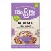 A resealable 450g Bio&Me Fruit & Nut muesli bag stands upright with a cream-and-green label and fruit illustrations. Loose muesli spills onto a wooden surface, revealing oats, dried cranberries, raisins, almonds and hazelnuts; a wooden scoop rests nearby.