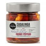 A clear glass jar displays glossy red cherry peppers packed tightly, each pepper plump and split to reveal smooth, white goat cheese. A simple label with green accents wraps the jar. Light reflects off brine, and the peppers’ stems and textured skins create a vivid, rustic appeal. soft seeds glisten