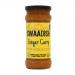 A cluster of clear glass jars shows glossy golden-orange ginger curry sauce, smooth with visible spice flecks. Each jar displays a bright label with the Swaadish logo and ginger illustration, green accents and silver lids. The jars are arranged neatly on a plain white background.