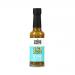 A 150ml clear glass bottle of Eaten Alive jalapeño-and-lime fermented hot sauce stands upright. The bright green sauce shows flecks of pepper and seeds. The colorful label displays jalapeño and lime artwork and bold brand typography; a metal cap seals the bottle.