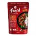 Bright red-orange sweet chilli stir-fry sauce fills a clear jar, its glossy, syrupy surface studded with chilli flakes and seeds. The label reads Fused by Fiona Uyema Dressings & Sauces in simple, modern type. Soft side lighting emphasizes texture and vibrant color.