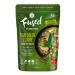 A glossy jar of bright emerald-green Thai curry paste sits open on a wooden board, flecked with chili seeds and kaffir lime rind. Fresh basil and sliced red chili scatter nearby. Light catches the oily sheen; textures range from smooth purée to coarse herb fragments. A small wooden spoon sits nearby