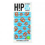 A brightly colored H!P chocolate wrapper sits against a white background; the logo appears bold with an exclamation point. The pack shows a broken oat-milk chocolate bar studded with salted pretzel pieces and an illustrated oat-milk splash, with scattered crumbs and pretzel fragments nearby.
