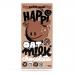 Brightly colored wrappers display the HAPPi brand name and playful typography. Each 80g chocolate bar shows 'Plain M!Lk' and 'Oat M!Lk' labels, a stylized oat illustration and a glossy chocolate splash. Twelve neatly stacked bars sit inside a partially opened carton. Soft light shows warm brown hue.