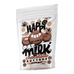 A glossy scatter of small, round milk chocolate buttons rests on a pale surface, their smooth domes catching soft light. A bright pouch stands behind them, displaying a cheerful logo and warm brown tones, with several buttons spilling from an opened corner. Soft shadows add depth and tiny highlights