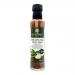 A photo shows six 250ml clear glass bottles of The Coconut Kitchen Chilli Garlic & Basil Stir-Fry Sauce lined up. Each has a green cap and cream label with illustrations of chili, garlic and basil, bold brand text and amber-red sauce visible inside.