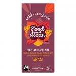 A rectangular wrapper shows Seed&Bean branding across the top in bold letters. Earthy kraft background meets deep brown chocolate tones. A torn-open chocolate bar reveals glossy dark squares studded with whole hazelnuts. Organic and fairtrade badges sit beside simple botanical accents. Subtle green.