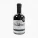 The photo shows six glass bottles of Wild Island Blackberry Balsamic dressing and sauces. Deep purple‑brown liquid glistens inside clear bottles, each bearing a colorful Wild Island label; natural light highlights the glossy texture against a neutral background.