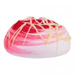 A heap of airy meringue clouds in soft raspberry pink and creamy white sits scattered across a pale surface. Each swirl shows crisp, glossy ridges; tiny dried raspberry crumbs and delicate white flower-shaped confections punctuate the composition, casting gentle shadows. Soft highlights glint peaks.