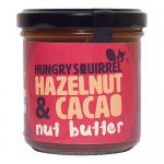 Photo shows six 180 g jars of Hungry Squirrel Hazelnut & Cacao spread arranged in two rows of three on a neutral surface. Clear glass jars reveal glossy brown spread; labels feature a stylized squirrel, product name and icons; silver lids reflect light. soft shadows and subtle reflections add depth.